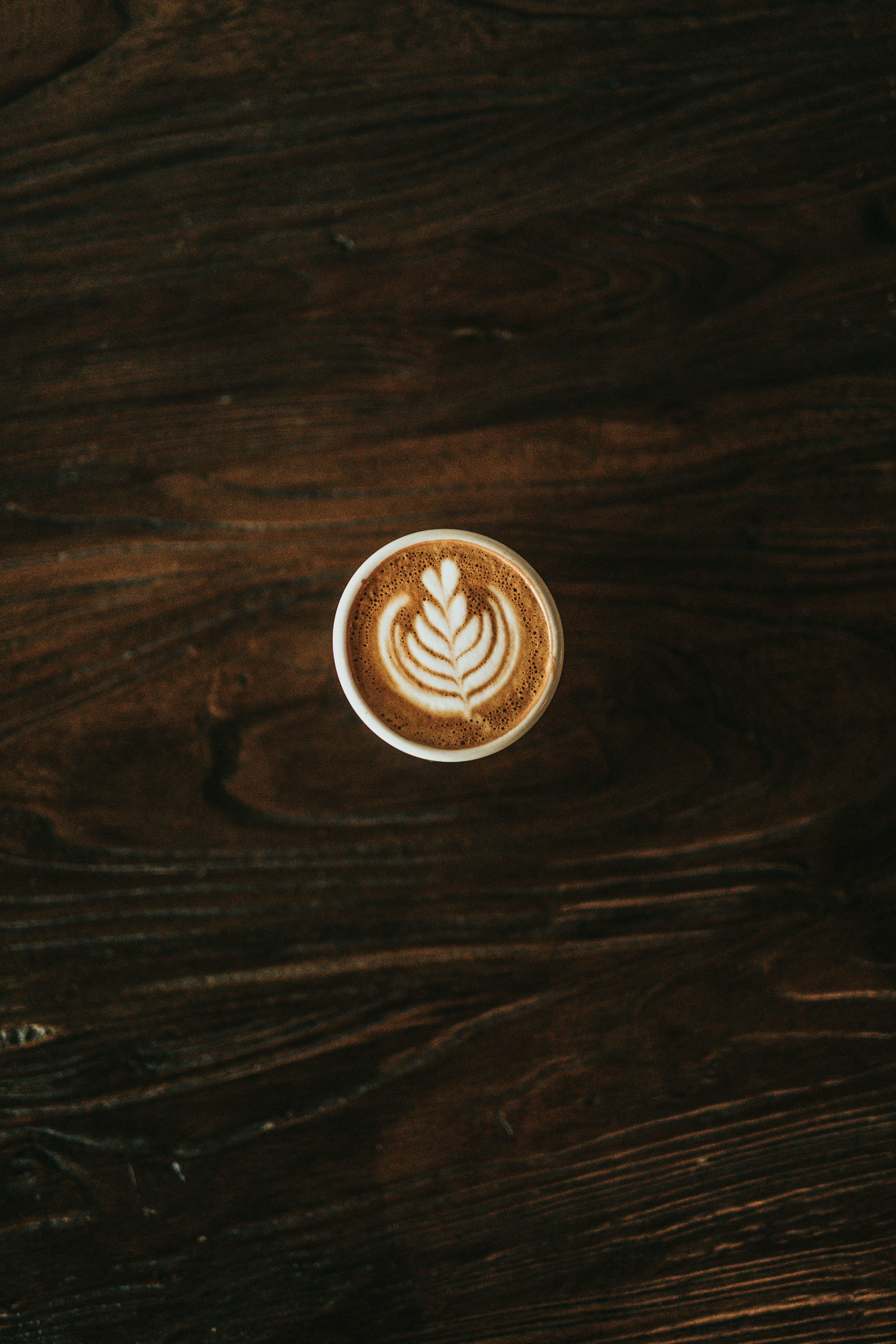 Top view of latte art on a dark wooden table